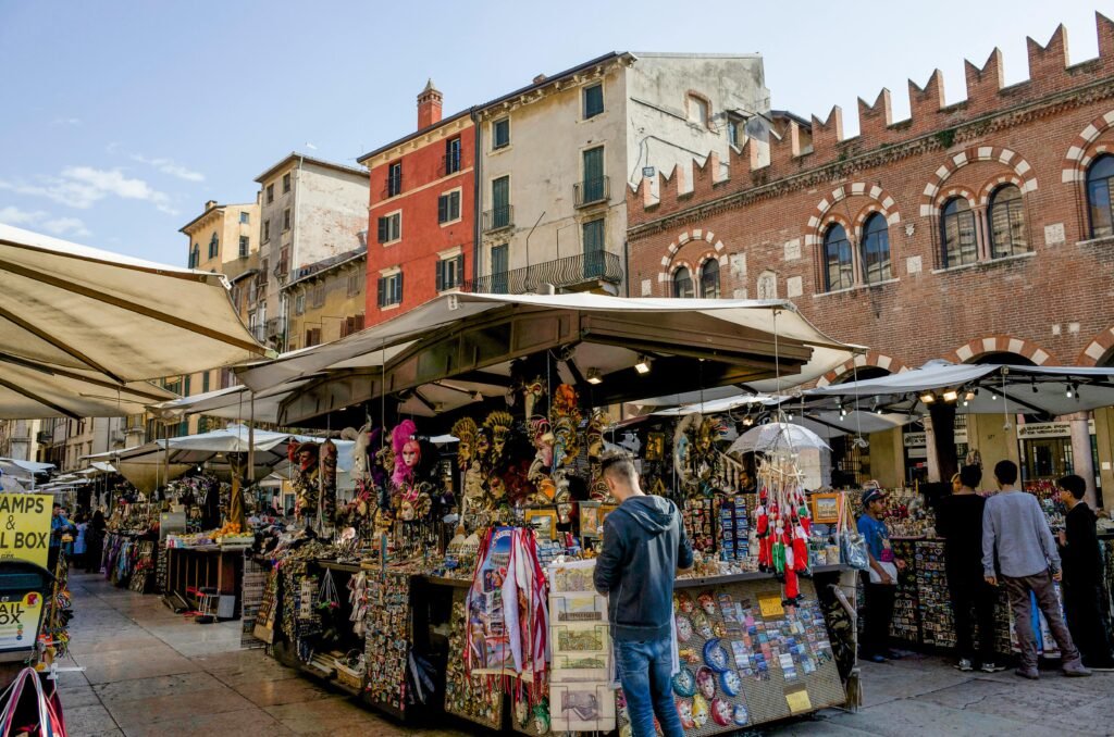 Foreign family receiving Italian residency permit through Your Assist in Italy Foreign family receiving Italian residency permit through Your Assist in Italy Job in italy Lively street market scene in Verona, showcasing local crafts and architecture.