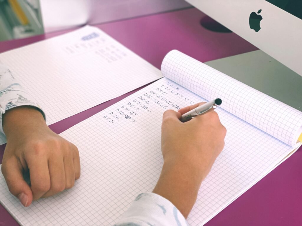 pexels photo 3987006 3987006 Close-up of a student writing on a notepad in a Milano classroom setting, enhancing education and learning concepts.